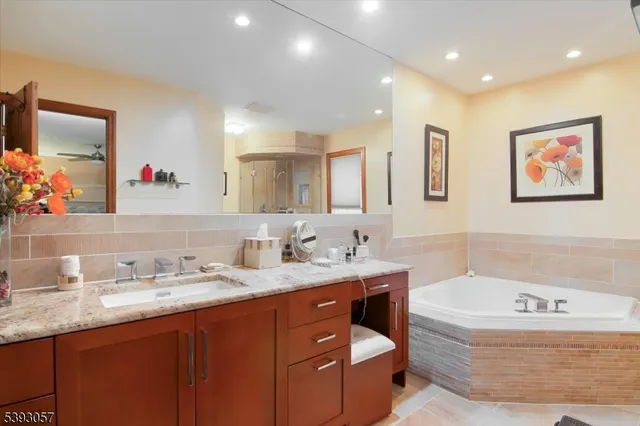 a bathroom with a tub a sink and mirror