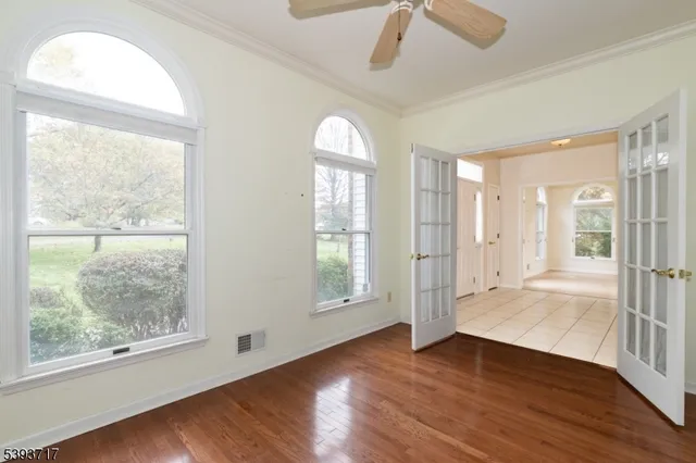 an empty room with a window and ceiling fan