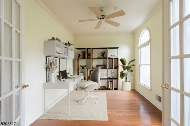 an empty room with windows and fan