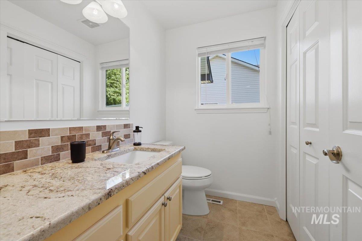 2075 North Springland Place Boise, ID 83713 - Photo 36 of 49 Bathroom featuring a single vanity with stone-finish countertop, undermount sink, and brushed nickel faucet