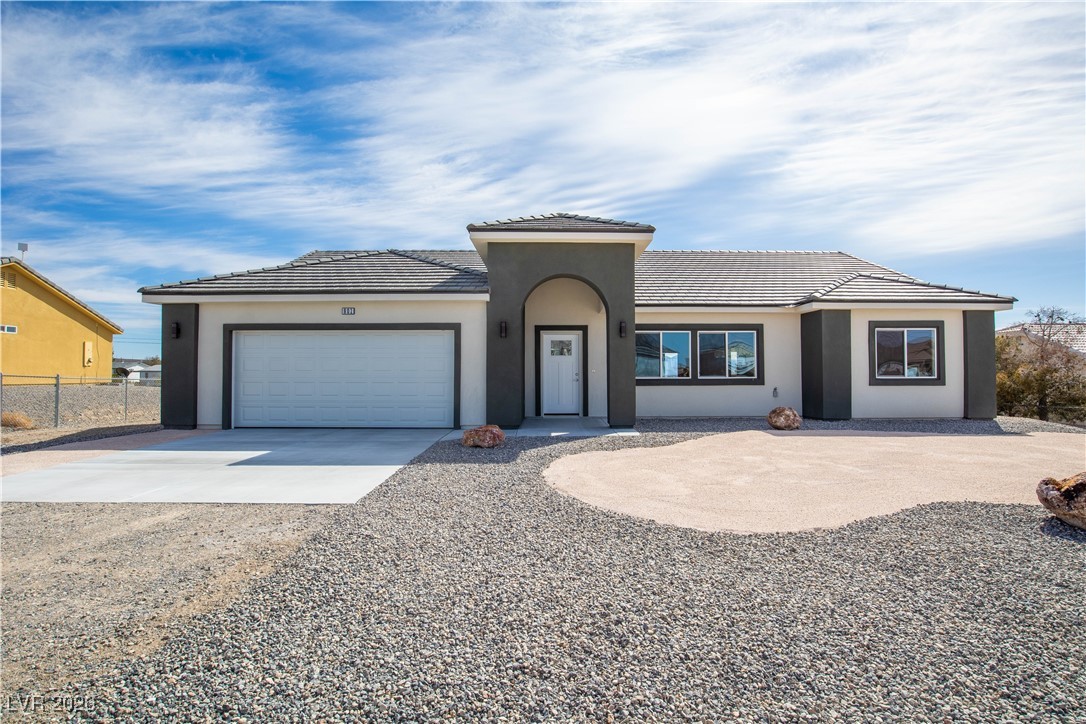 View of front of property with stucco siding, a tile roof, fence, concrete driveway, and an attached garage