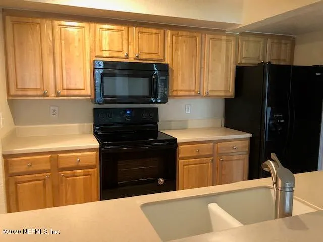 a kitchen with stainless steel appliances a stove microwave and refrigerator