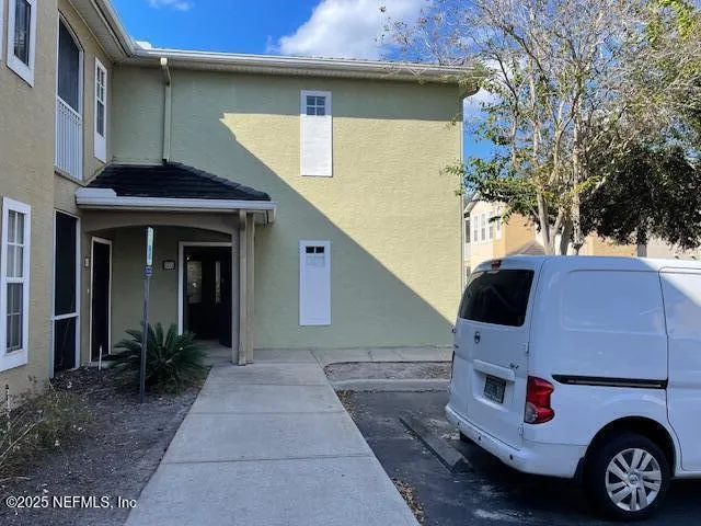 a view of a fountain in front of a house with large trees
