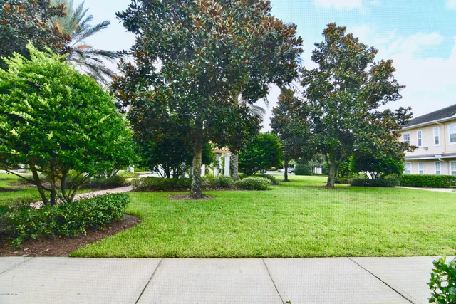 a view of swimming pool with lawn chairs and plants