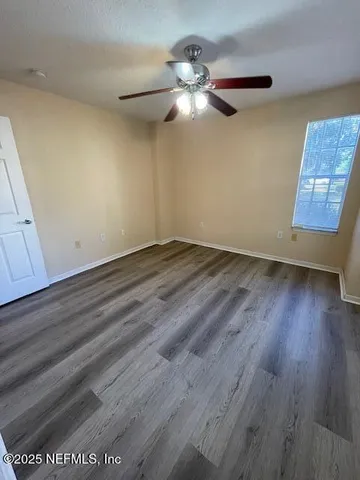a view of an empty room with wooden floor