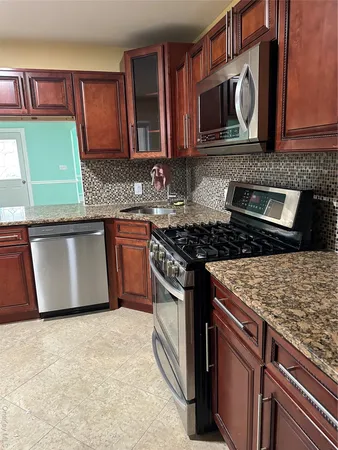 a kitchen with stainless steel appliances granite countertop a stove microwave and cabinets