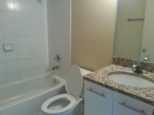 a bathroom with a granite countertop sink toilet and bathtub