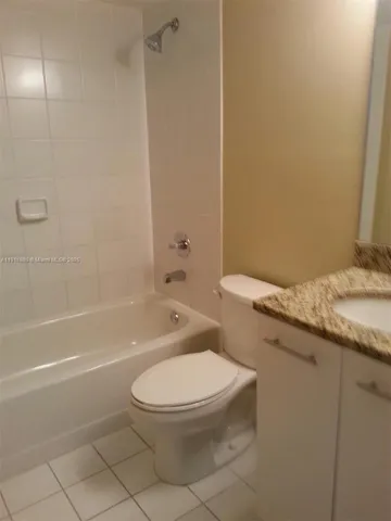 a white toilet and tub sitting next to a bathroom sink