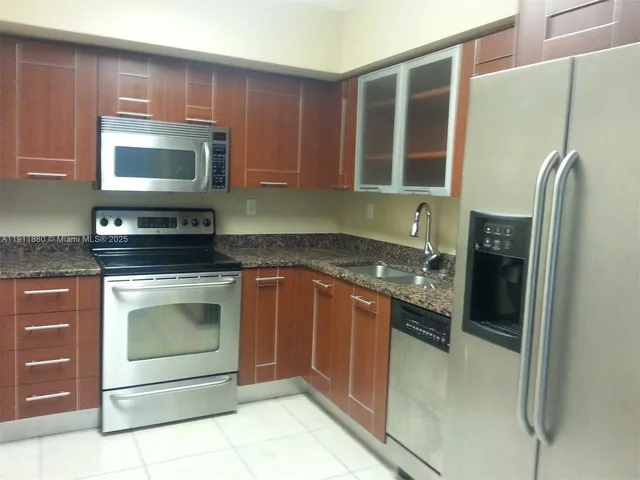 a kitchen with stainless steel appliances granite countertop a stove microwave and refrigerator