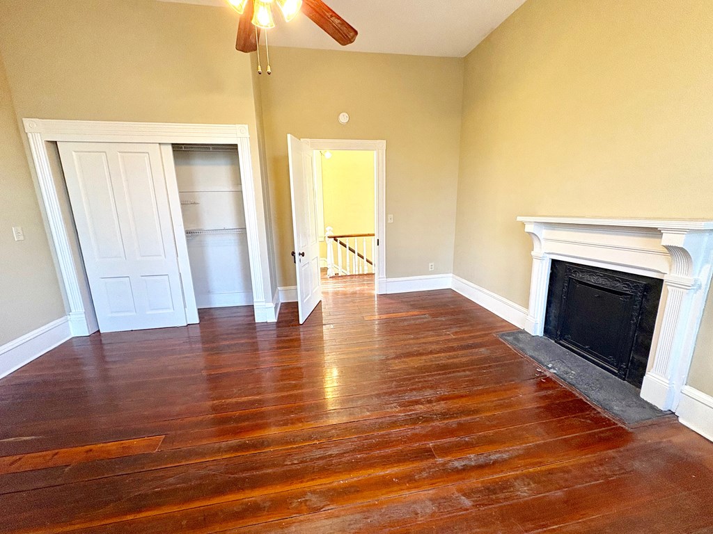 110 7th Street Columbus, GA 31901 - Photo 17 of 24 a view of an empty room with wooden floor fireplace and a window