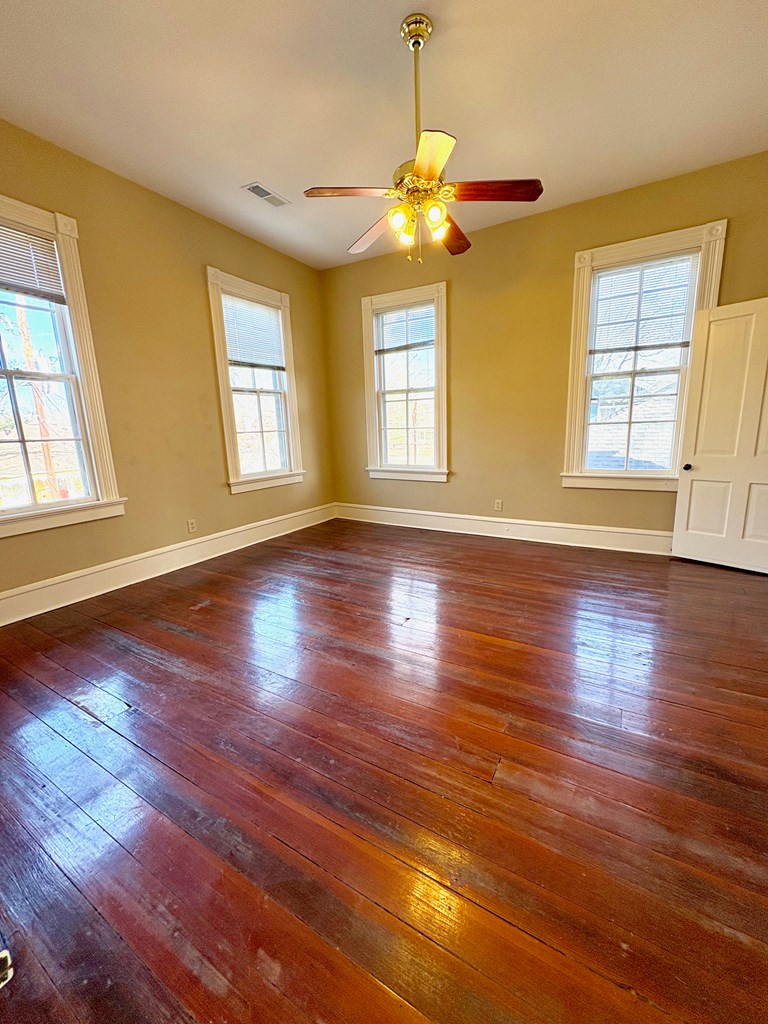 110 7th Street Columbus, GA 31901 - Photo 21 of 24 a view of an empty room with wooden floor and a window