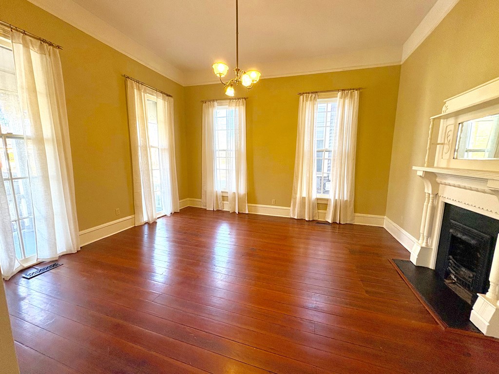 110 7th Street Columbus, GA 31901 - Photo 5 of 24 a view of an empty room with wooden floor and a window
