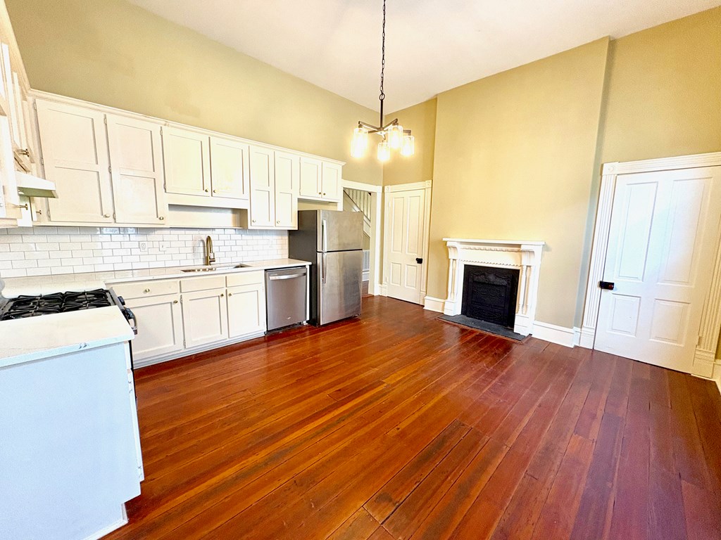 110 7th Street Columbus, GA 31901 - Photo 9 of 24 a view of a kitchen with a stove cabinets and wooden floor