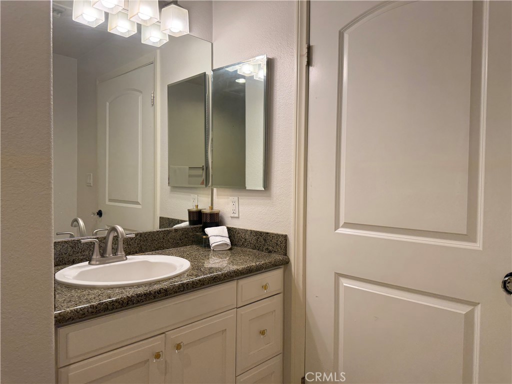 3740 Santa Rosalia Drive, Unit 425 Los Angeles, CA 90008 - Photo 16 of 24 a bathroom with a granite countertop sink and a mirror
