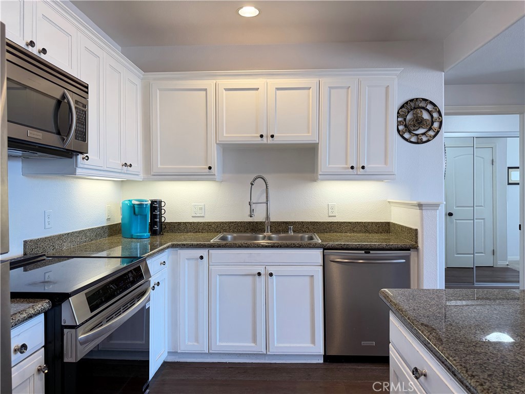3740 Santa Rosalia Drive, Unit 425 Los Angeles, CA 90008 - Photo 7 of 24 a kitchen with granite countertop a stove sink and cabinets
