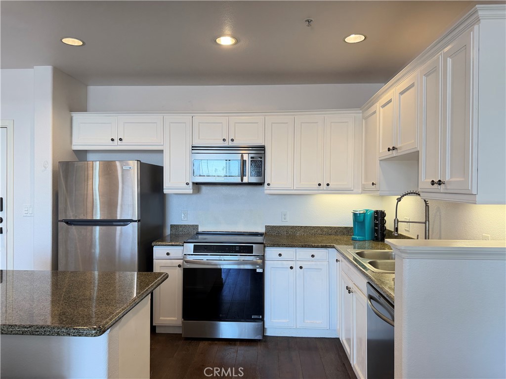 3740 Santa Rosalia Drive, Unit 425 Los Angeles, CA 90008 - Photo 8 of 24 a kitchen with stainless steel appliances granite countertop a refrigerator sink stove and white cabinets