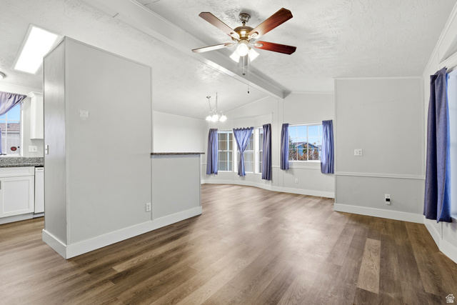 150 West 7500th South, Unit 55 Midvale, UT 84047 - Photo 8 of 28 Unfurnished living room featuring wood finished floors, beamed ceiling, ceiling fan, and a chandelier