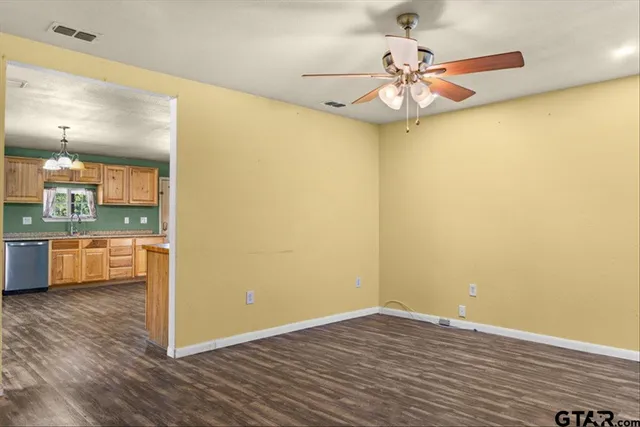 a view of a room with wooden floor and a ceiling fan