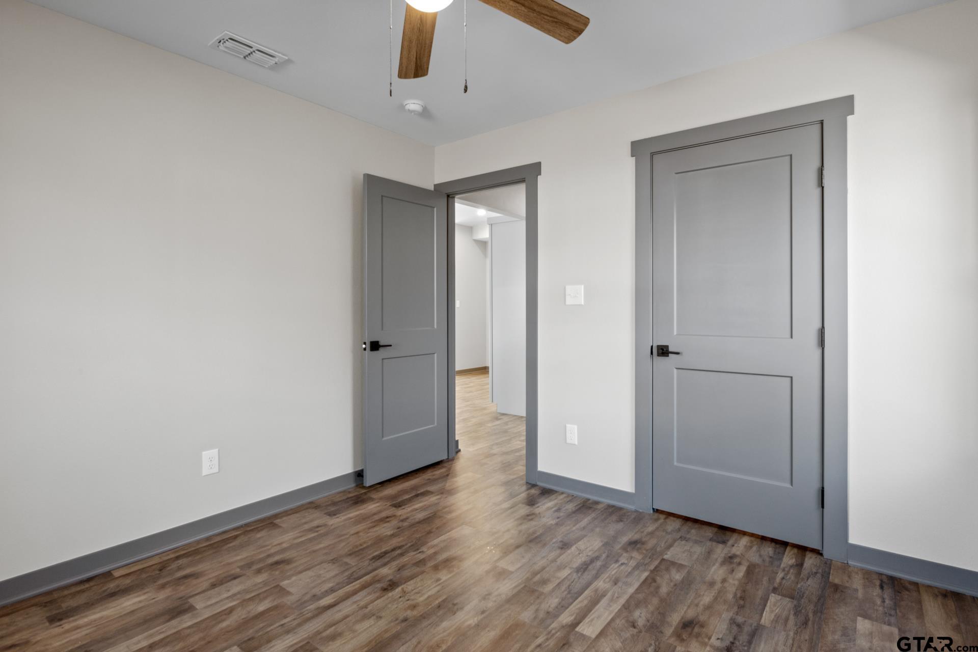 109 Yates Street Mount Vernon, TX 75457 - Photo 14 of 23 an empty room with wooden floor closet and chandelier fan