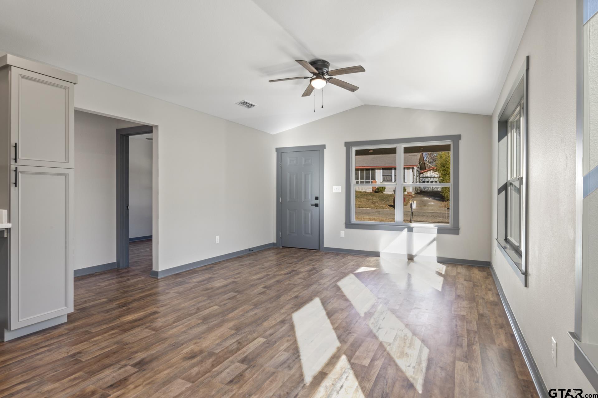 109 Yates Street Mount Vernon, TX 75457 - Photo 6 of 23 a view of a livingroom with wooden floor and a ceiling fan