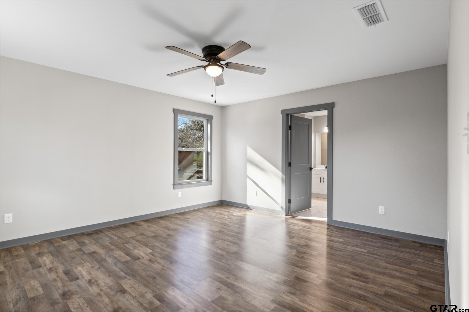 109 Yates Street Mount Vernon, TX 75457 - Photo 9 of 23 a view of an empty room with a window and wooden floor