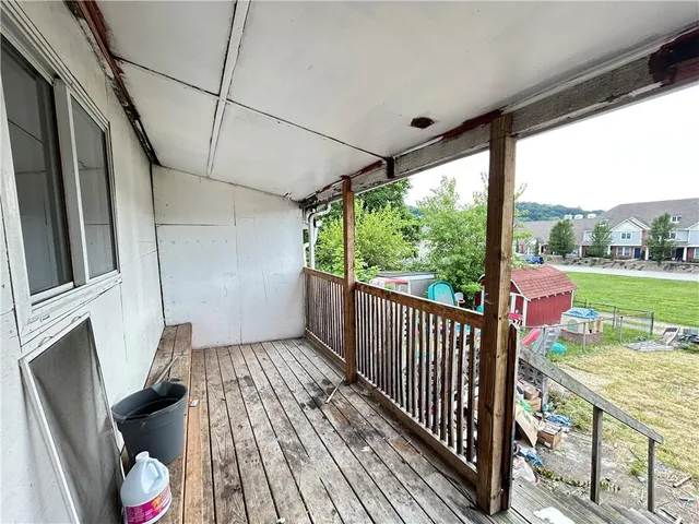 a view of a porch with wooden floor and outdoor seating