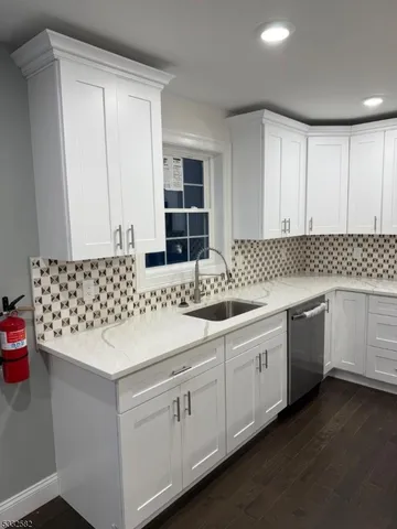 a kitchen with granite countertop white cabinets and white appliances