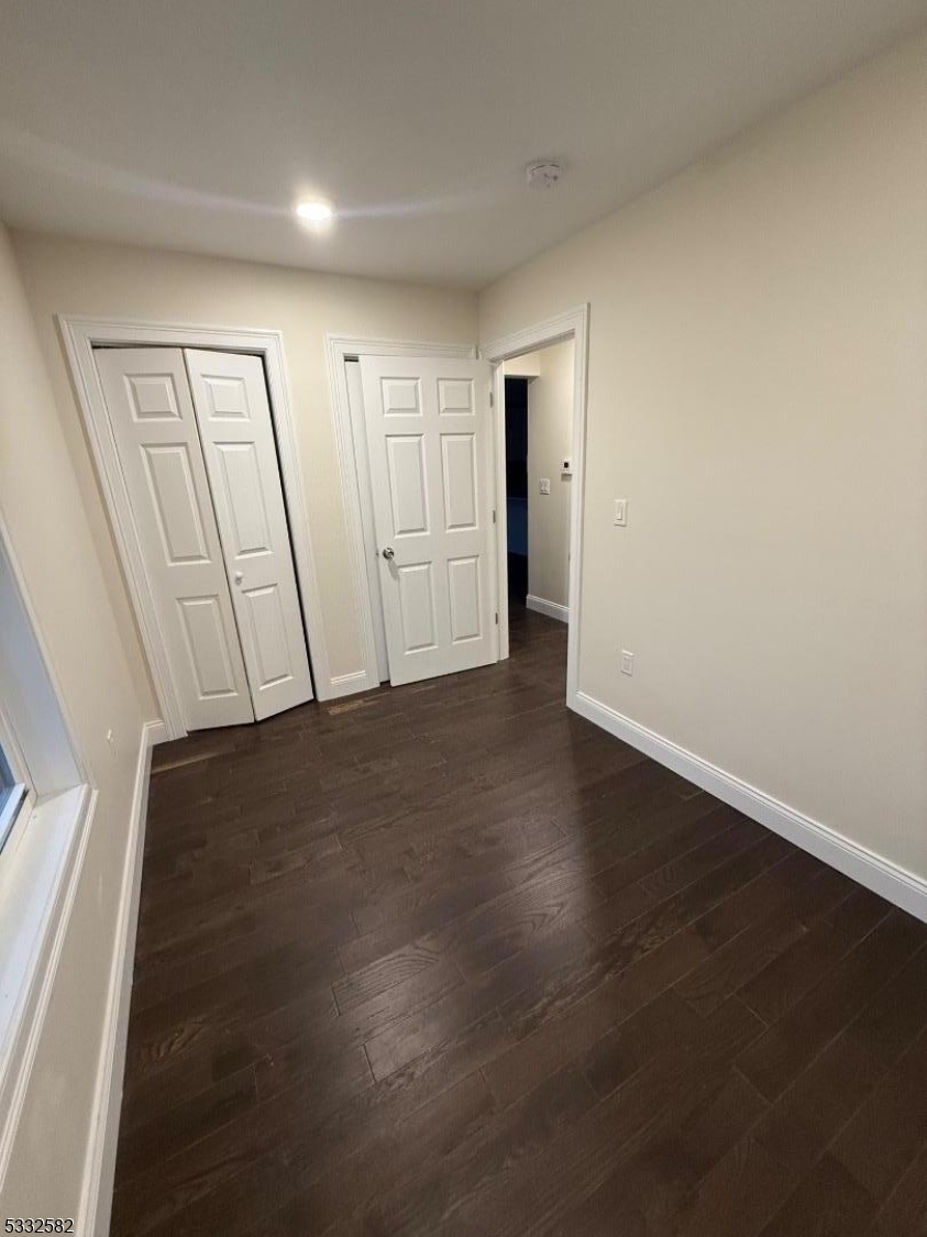 7 Maple Street Bloomfield, NJ 07003 - Photo 9 of 13 an empty room with wooden floor and windows