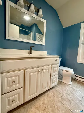 a bathroom with a toilet a sink and mirror