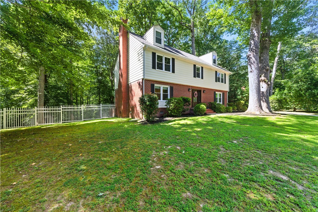 111 Braddock Road Williamsburg, VA 23185 - Photo 43 of 43 Colonial house featuring brick siding, a chimney, and view of scattered trees