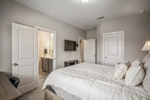 a bedroom with a bed and a flat screen tv