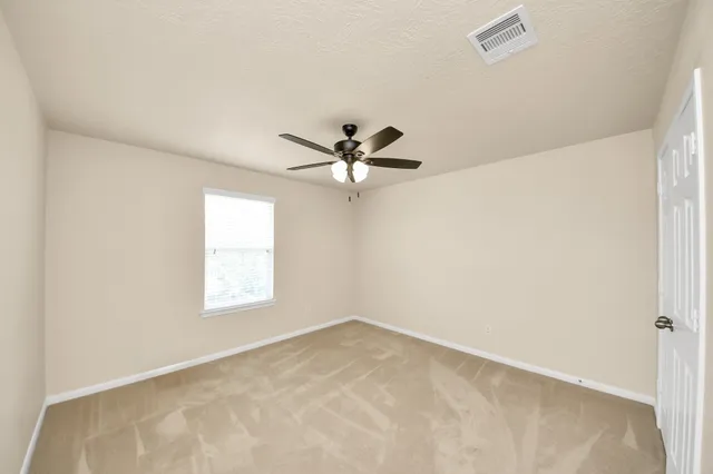 a view of a room with a ceiling fan and a window