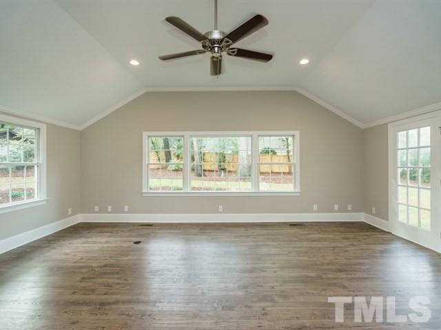 3317 Redbud Lane Raleigh, NC 27607 - Photo 15 of 25 an empty room with wooden floor chandelier fan and windows