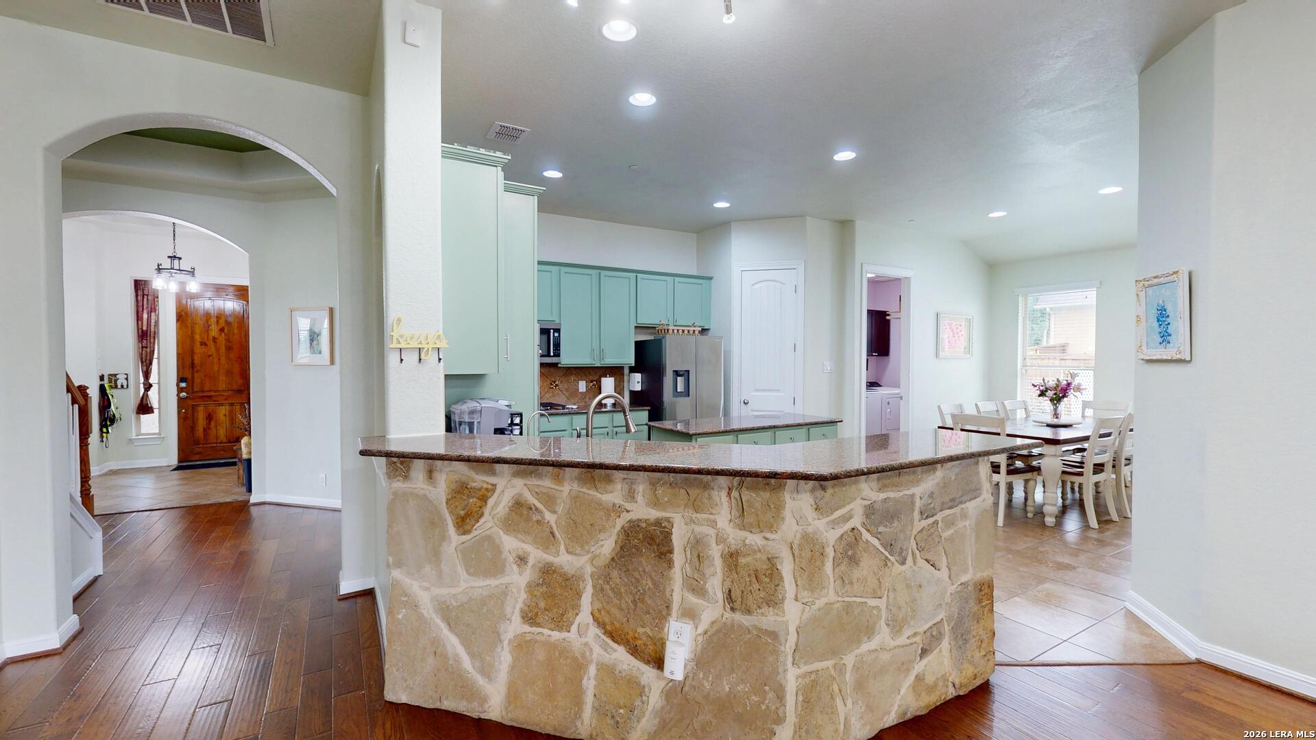 10111 Shallow Bank Converse, TX 78109 - Photo 13 of 65 a view of a kitchen with kitchen island granite countertop wooden floors and a view of living room