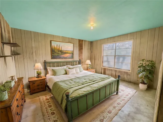 a bedroom with a large bed and potted plant