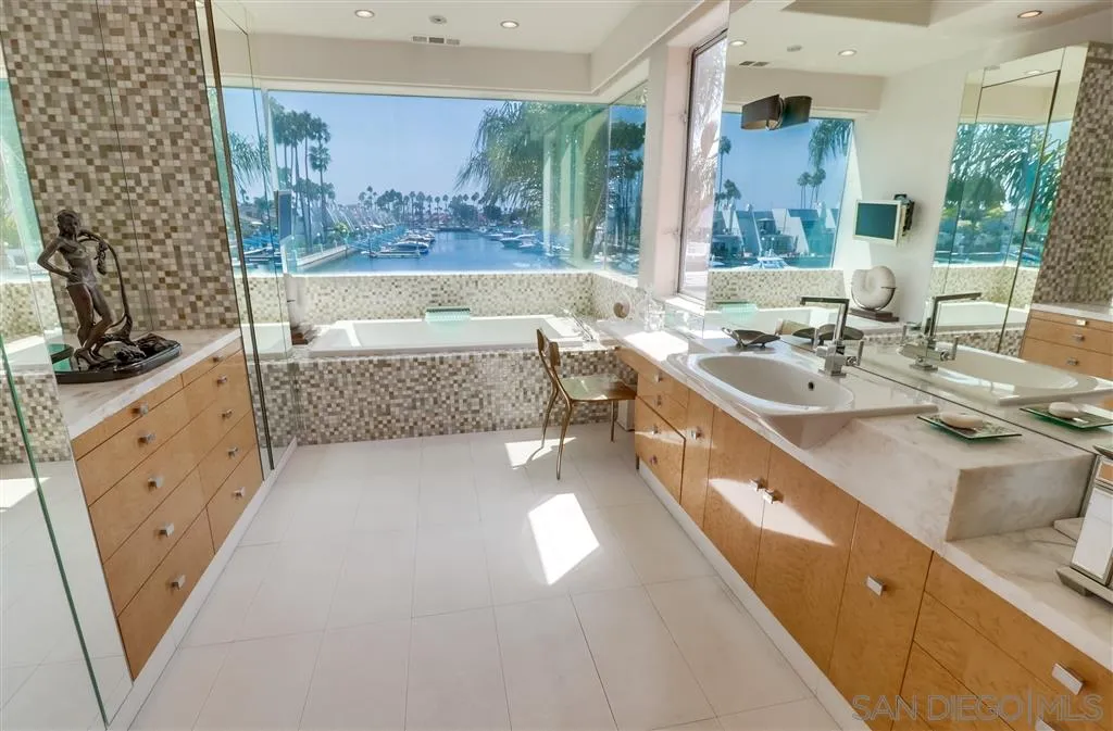 22 Green Turtle Road Coronado, CA 92118 - Photo 15 of 25 a bathroom with a double vanity sink a mirror and a bathtub