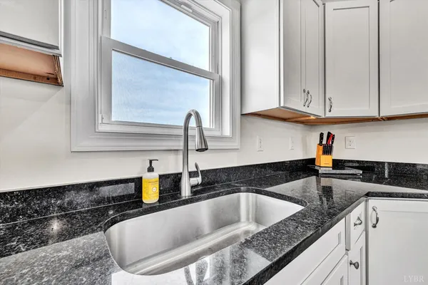 a kitchen with granite countertop a sink and a stove top oven