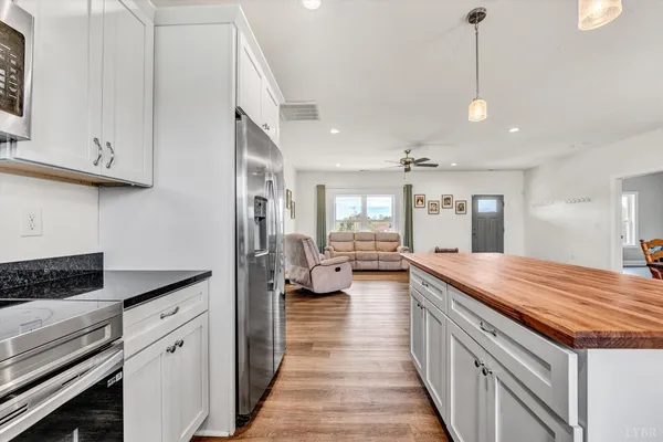 a spacious kitchen with stainless steel appliances granite countertop a lot of counter space and wooden floors