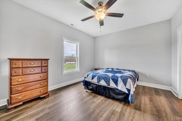 a spacious bedroom with a bed and a ceiling fan