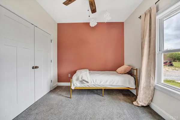 a bedroom with a bed and a window