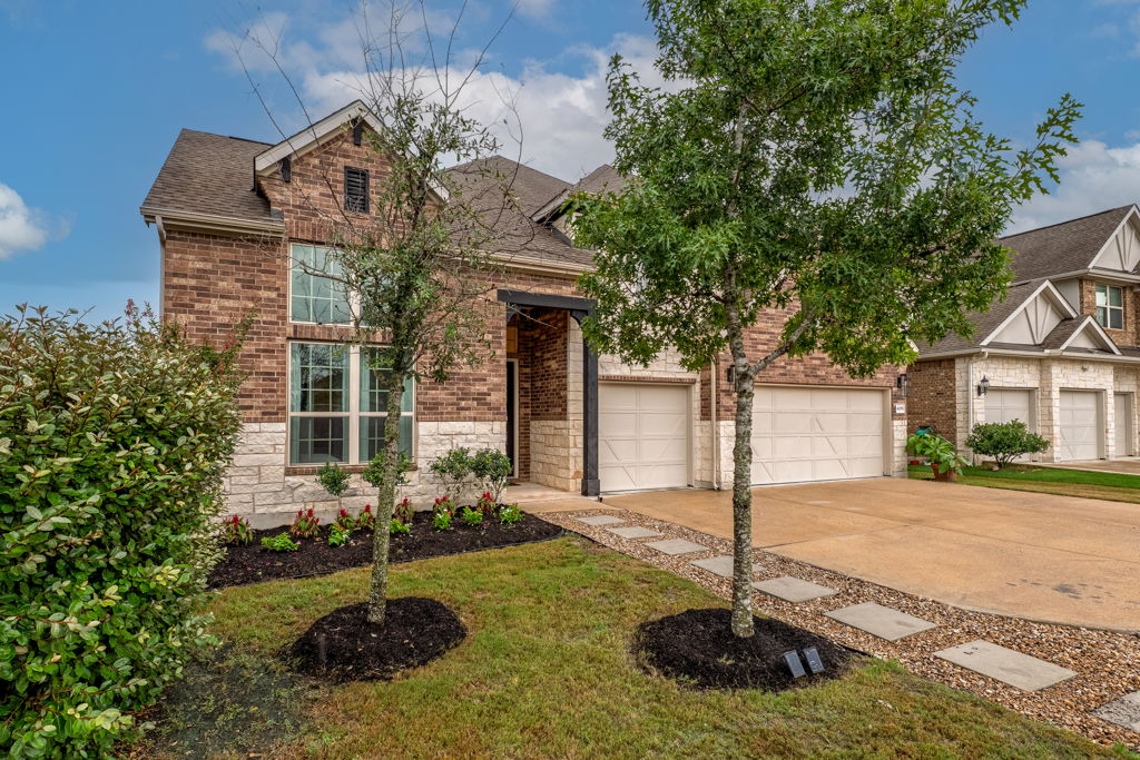 4209 Brean Down Road Pflugerville, TX 78660 - Photo 30 of 31 A classic brick and stone facade welcomes with lush landscaping and a functional three-car garage.