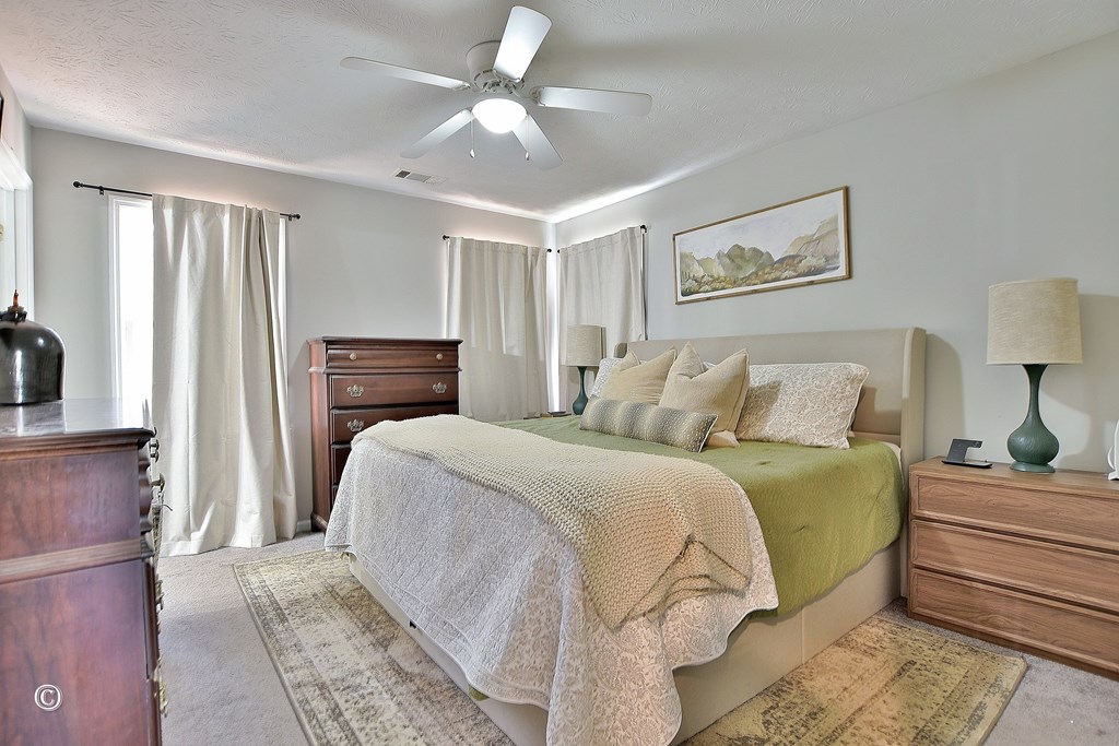 180 Mulberry Lane Fortson, GA 31808 - Photo 14 of 22 a bedroom with a bed and a chandelier