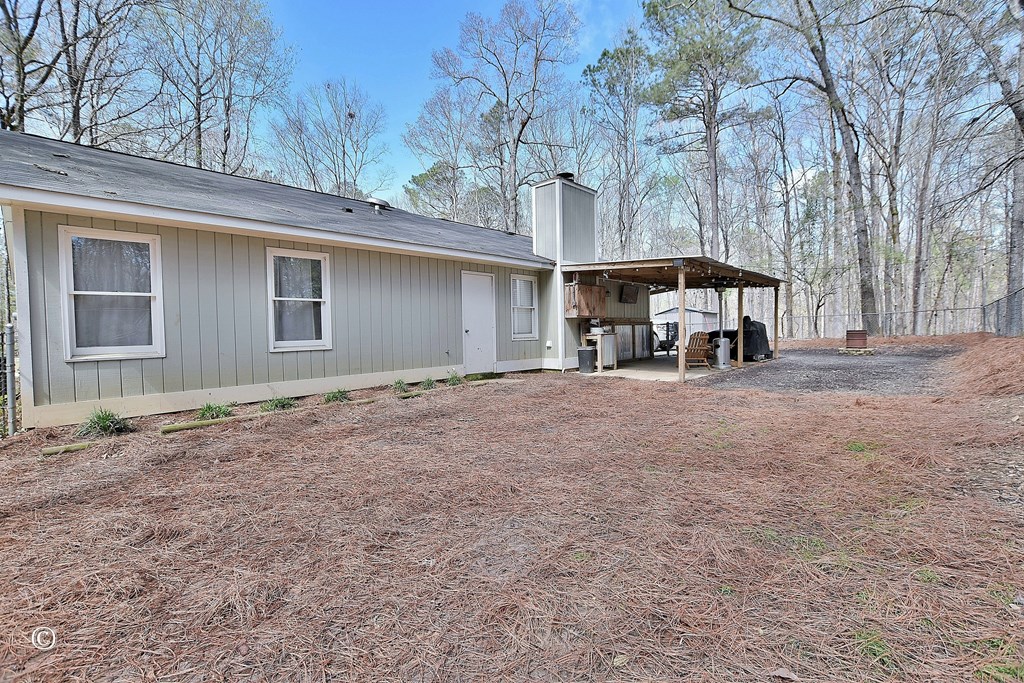 180 Mulberry Lane Fortson, GA 31808 - Photo 20 of 22 a view of a house with a large tree and wooden fence