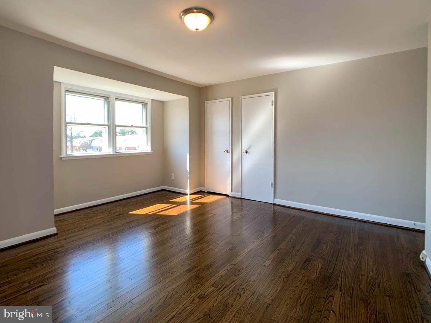 1567 Parklane Road Swarthmore, PA 19081 - Photo 14 of 23 an empty room with wooden floor and windows