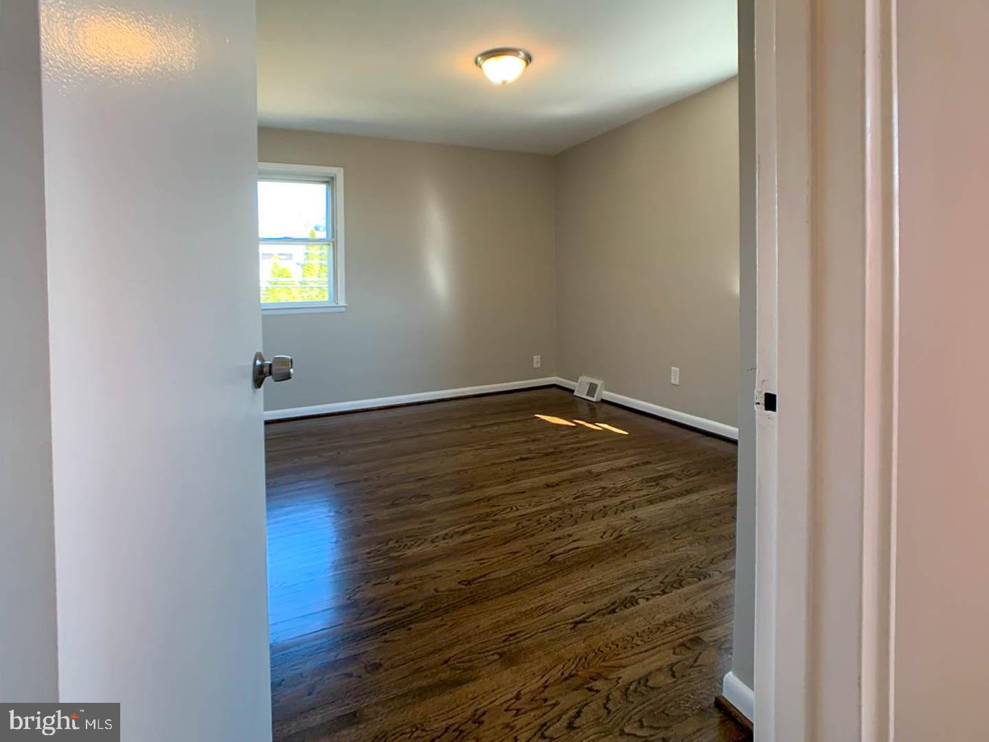 1567 Parklane Road Swarthmore, PA 19081 - Photo 17 of 23 an empty room with wooden floor and windows