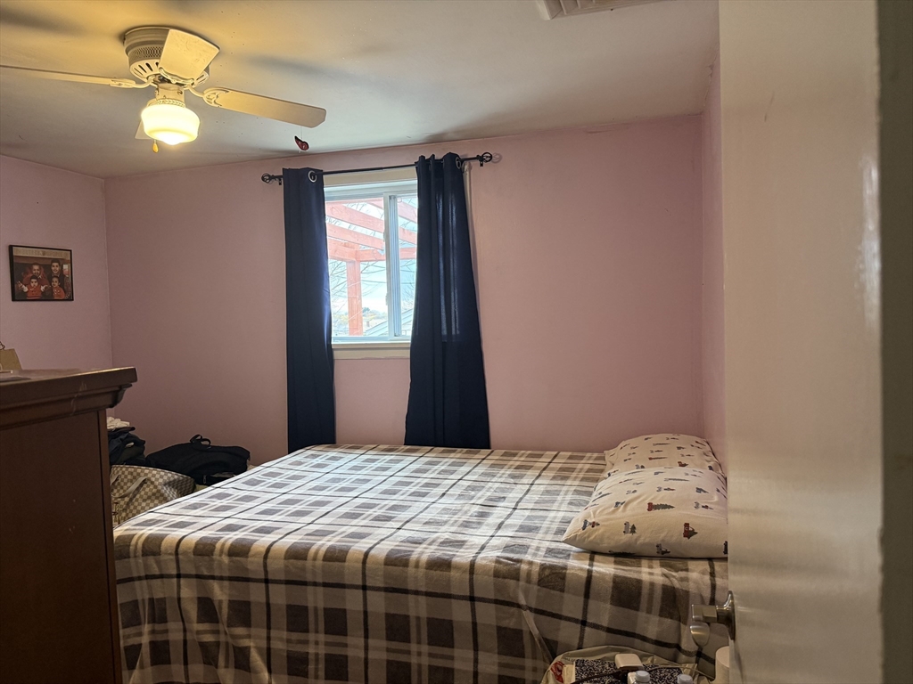 77 Roland Road Revere, MA 02151 - Photo 11 of 13 a bedroom with a bed and a chandelier