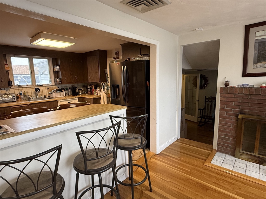 77 Roland Road Revere, MA 02151 - Photo 13 of 18 a kitchen with a table chairs refrigerator and cabinets