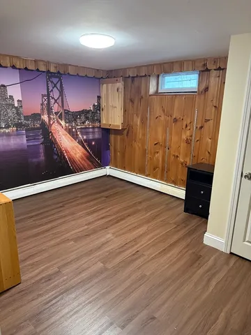 a view of a room with wooden floor and furniture