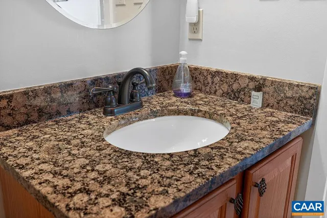 a bathroom with a granite countertop sink and a mirror