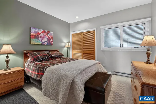 a bedroom with a bed and a flat tv screen on a dresser